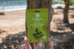 Holding a verdes cannabis product outdoors 