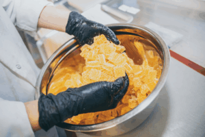 A person making orange cannabis edibles 